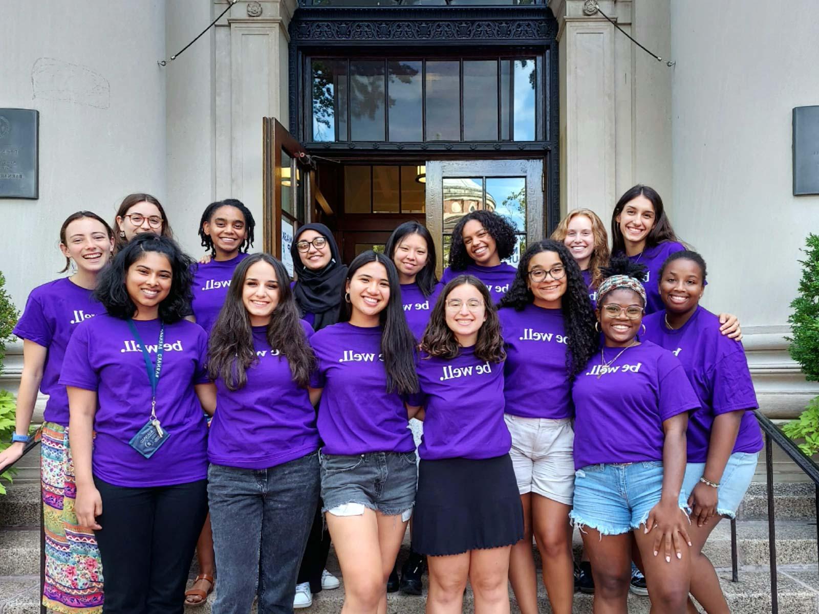 Wellness Spot peer educators stand on the steps of Barnard Hall wearing purple